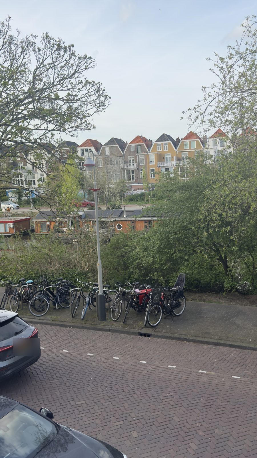 Uitzicht over de Suezkade met fietsenrekken, het Verversingskanaal en woonboten